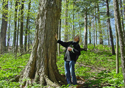 Man standing next to large tree